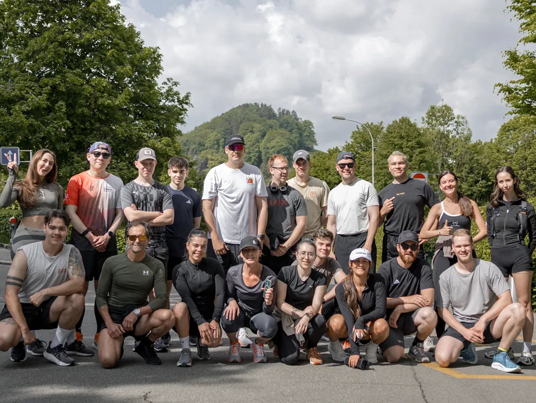 Gruppenfoto der WE•TRST Run Club St. Gallen Teilnehmer:innen nach einem Social Run in St. Gallen, umgeben von grünen Bäumen im Hintergrund.