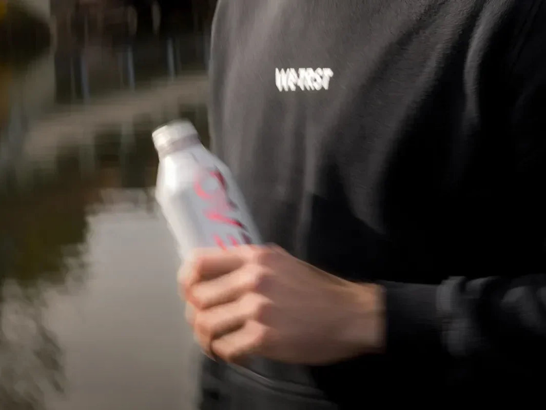 WE•TRST Run Club Teilnehmer in schwarzem Hoodie mit PEAQ Getränk in St. Gallen