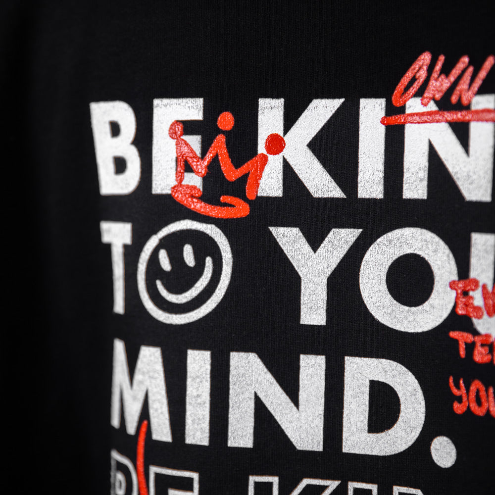 Detaillierte Nahaufnahme des grafischen Aufdrucks „Be Kind to Your Mind“ auf dem WE•TRST Special Edition T-Shirt mit weißen und roten Typografie-Elementen.