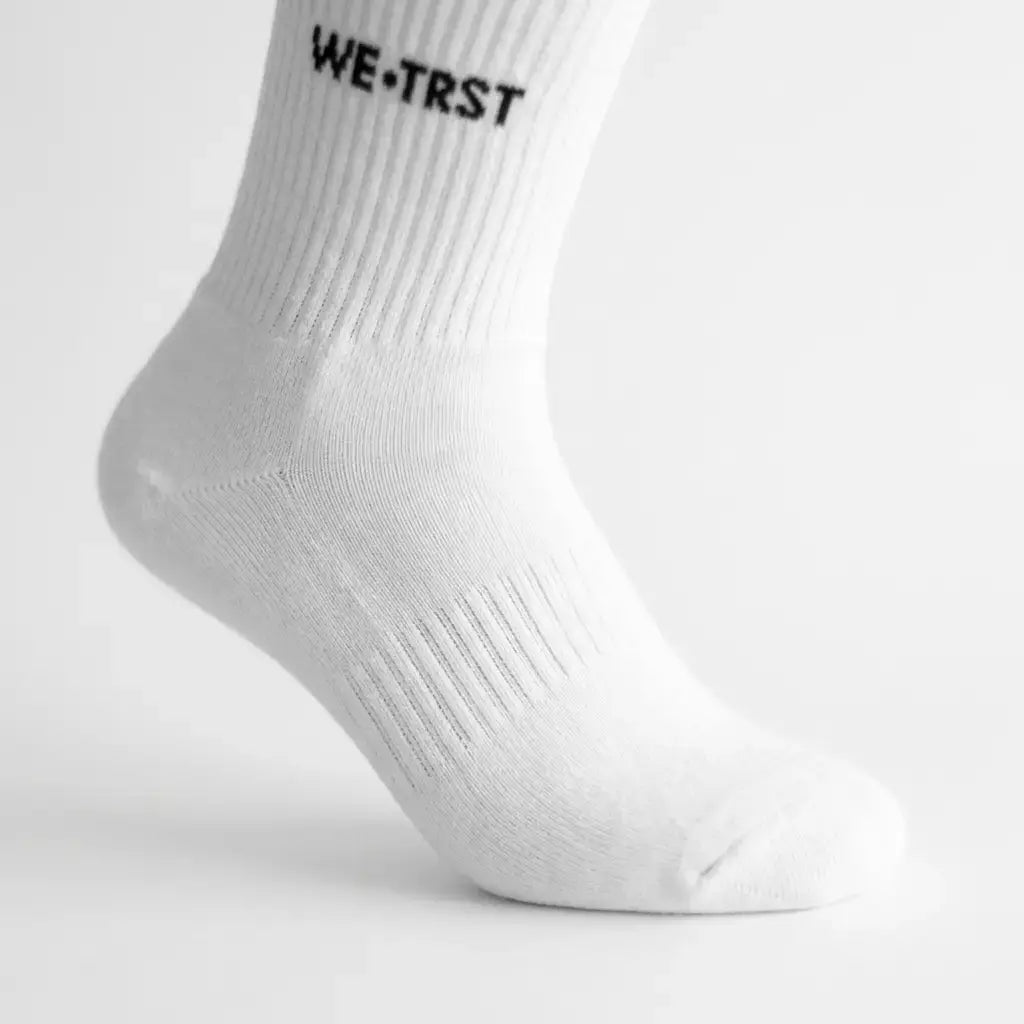 WE•TRST STEP•ONE Socks – weisse Crew Socke am Fuss in Seitenansicht