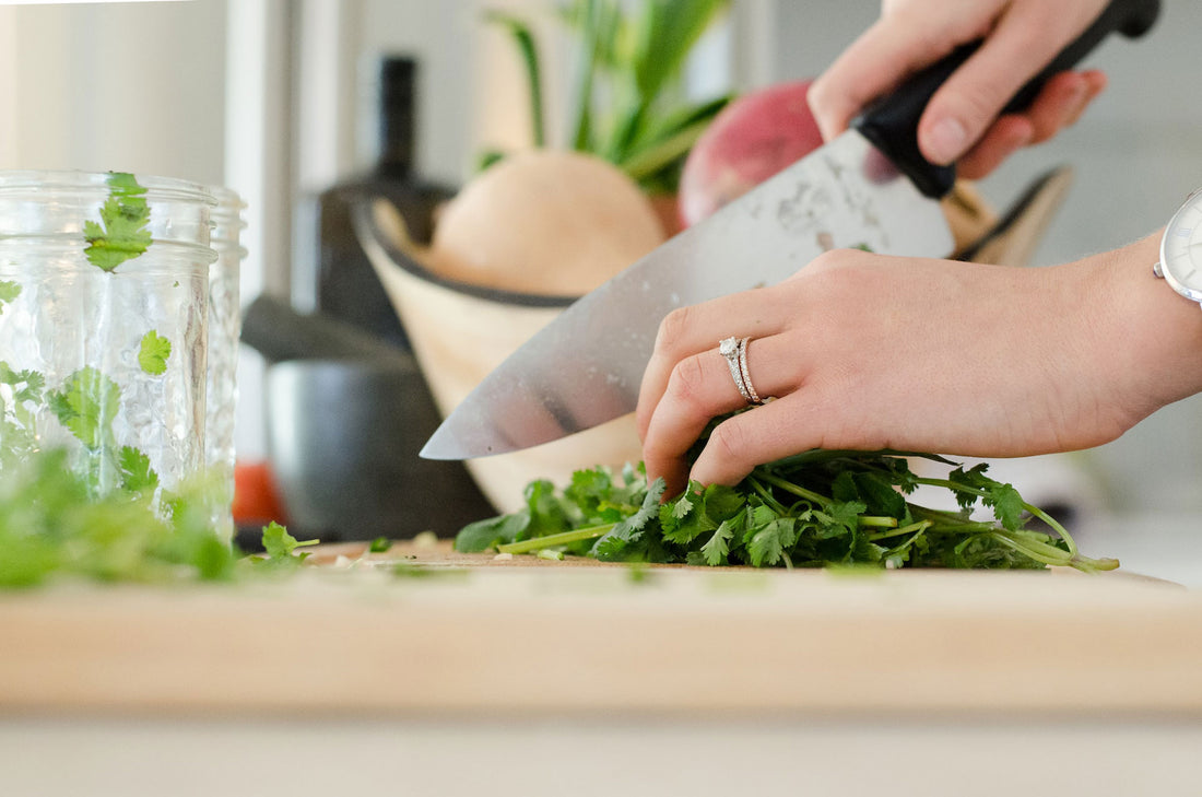 Das Bild zeigt ein Messer, das gerade verwendet wird, um Gemüse zu schneiden. Die Klinge ist aus nächster Nähe zu sehen und durchtrennt das Gemüse in einem präzisen und schnellen Schnitt.