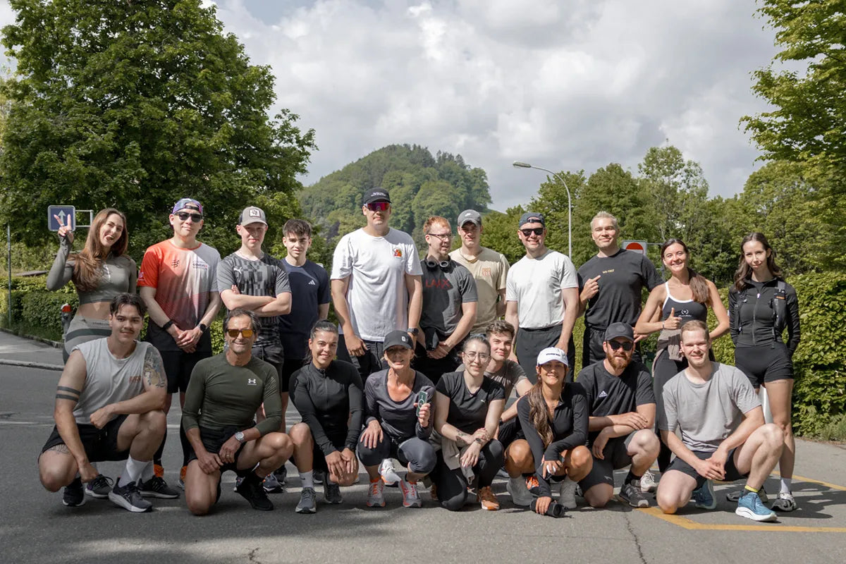 Gruppenfoto der WE•TRST Run Club St. Gallen Teilnehmer:innen nach einem Social Run in St. Gallen, umgeben von grünen Bäumen im Hintergrund.
