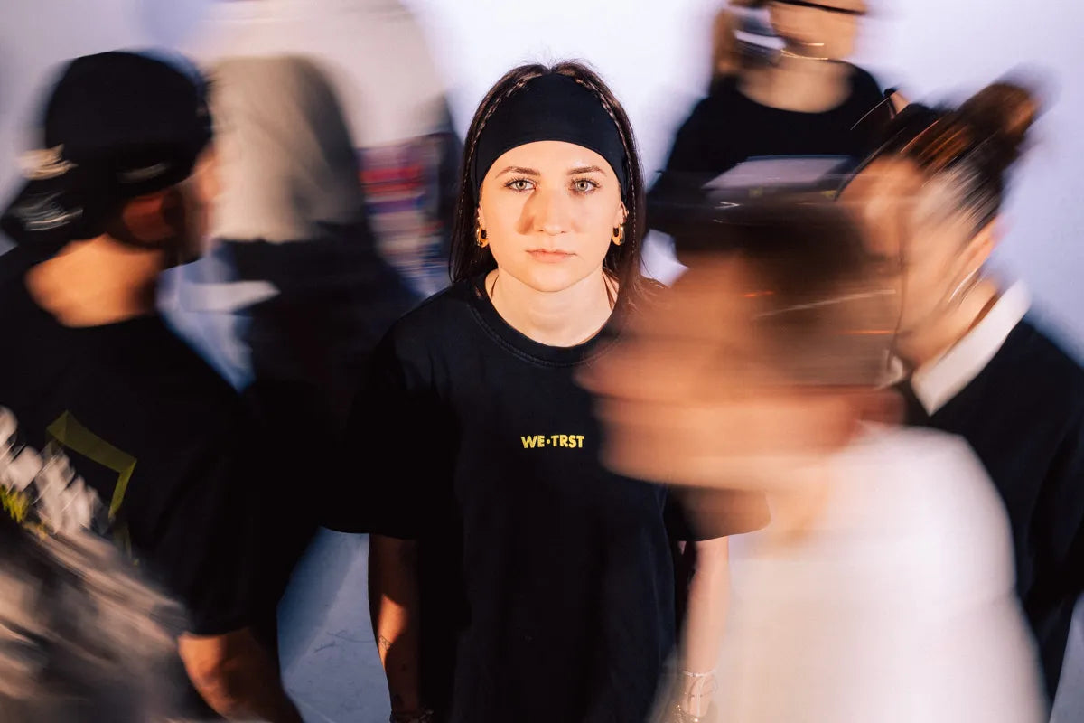 WE•TRST Portrait im Motion-Effekt – Person im Fokus während sich die Community bewegt