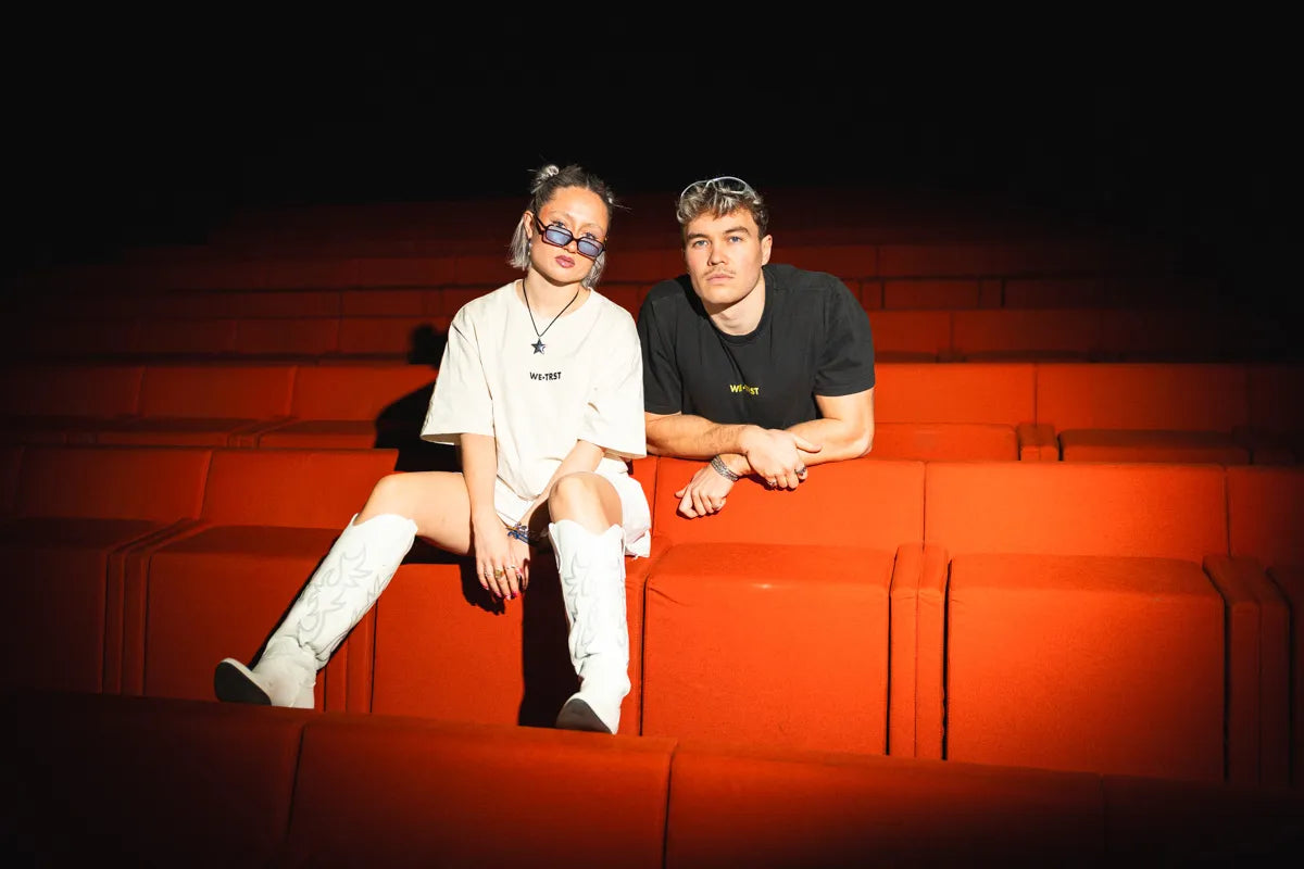 WE•TRST Urban Fashion Shooting im Kinosaal – zwei Models in Streetwear auf roten Sitzen