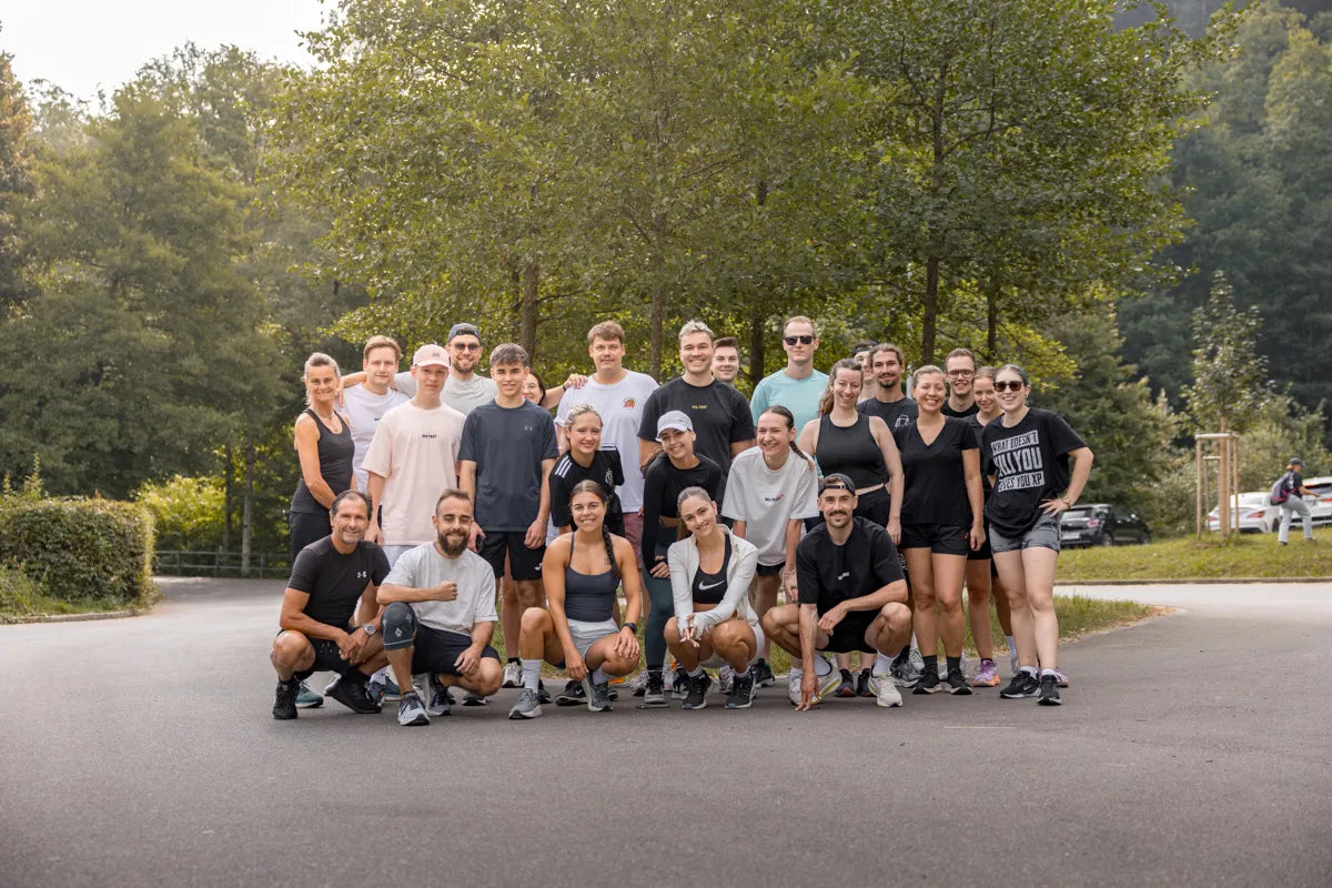 WE•TRST Run Club – Gruppenfoto der Läufer:innen in Sportkleidung im Grünen