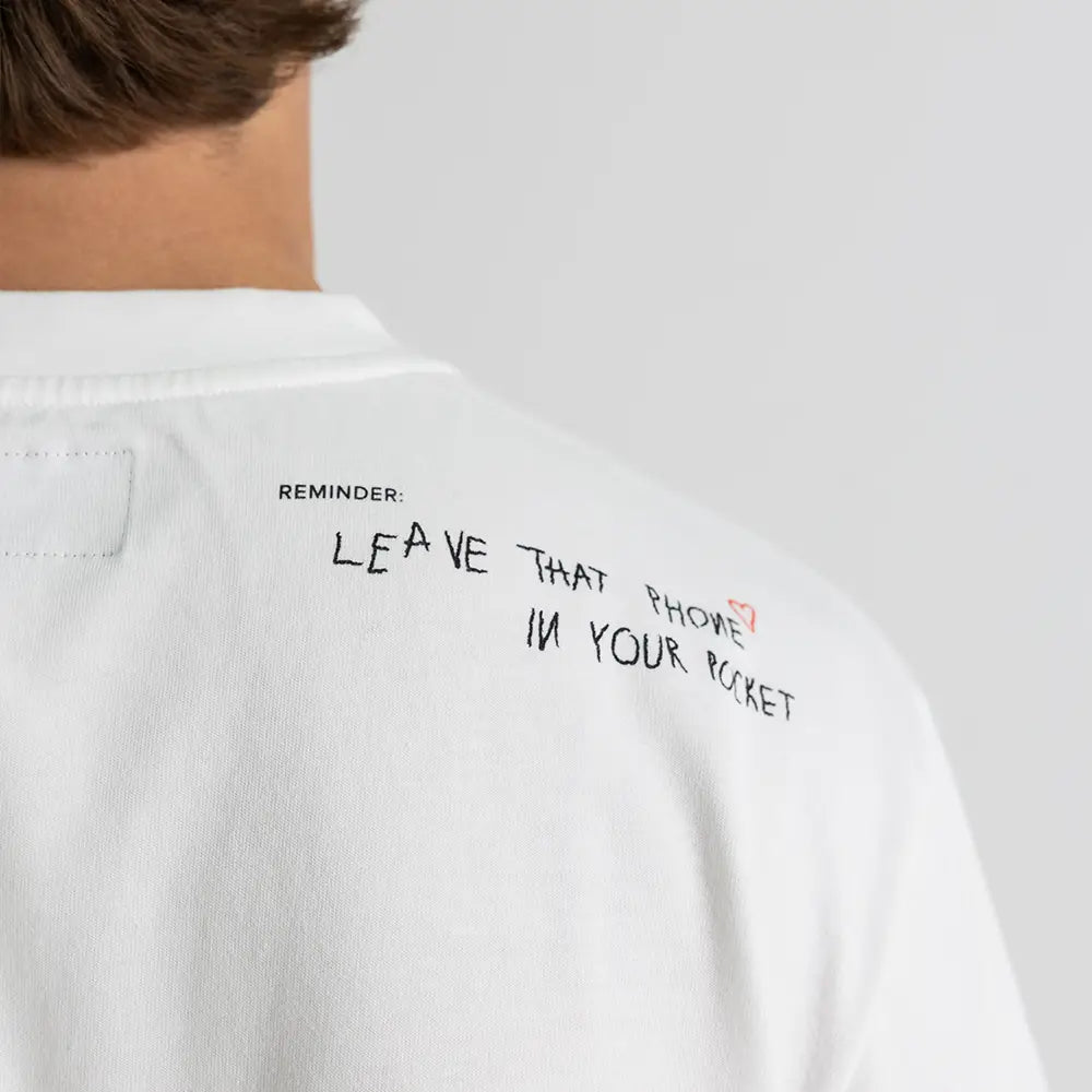 Schulter-Detail des Dangel Twins-Shirts mit handgeschriebenem Reminder: Leave that phone in your pocket – WE•TRST Streetwear-Statement.